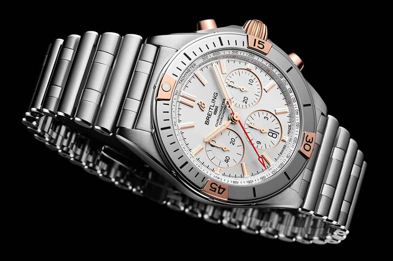 百年靈 Chronomat B01 42 配備銀色表盤、18k 紅金表冠和按鈕以及帶有 18k 紅金騎手標簽的表圈